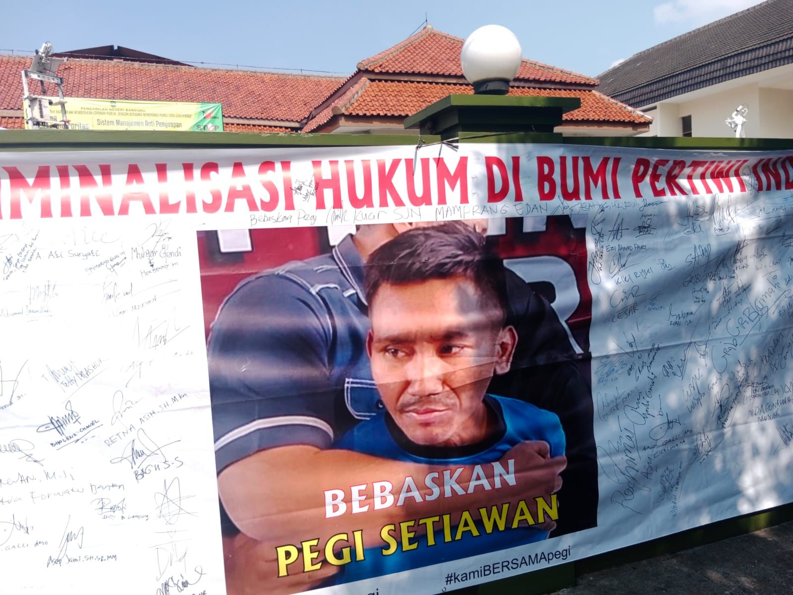 Poster Pegi Setiawan dipasang di pagar Gedung PN Bandung