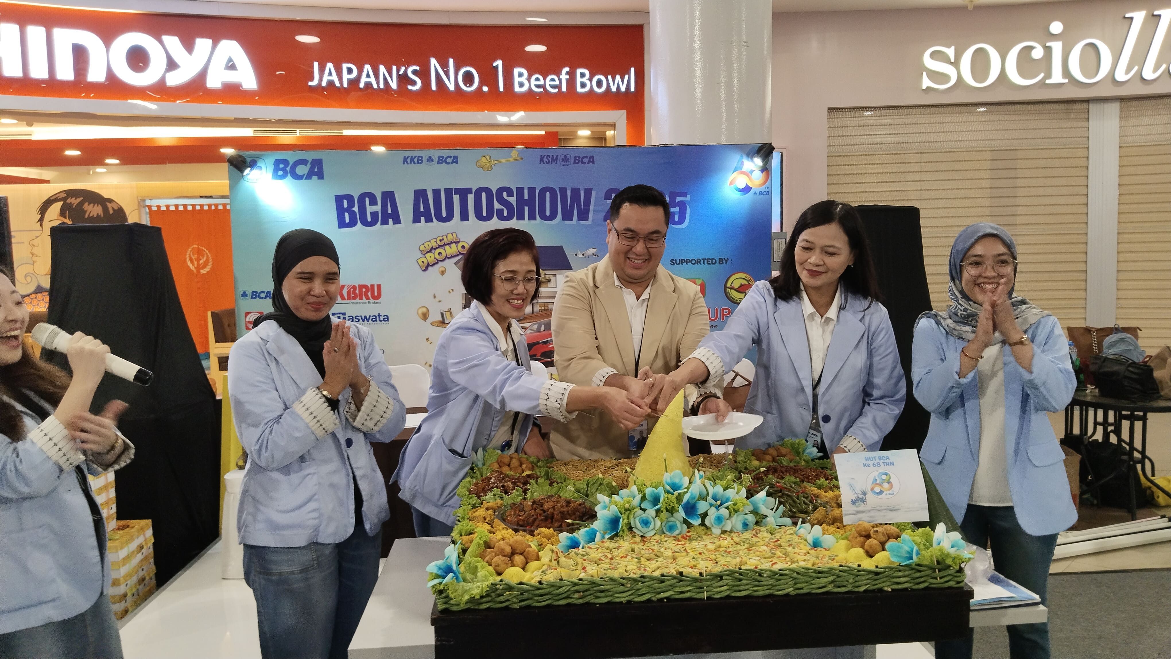 Kepala KCU BCA Tegal, Kenneth Sajuti, didampingi oleh para pengurus KCU BCA Tegal memotong tumpeng saat grand opening Autoshow BCA KCU Tegal 2025 di Pacific Mall Tegal, Jumat, 21 Februari 2025.