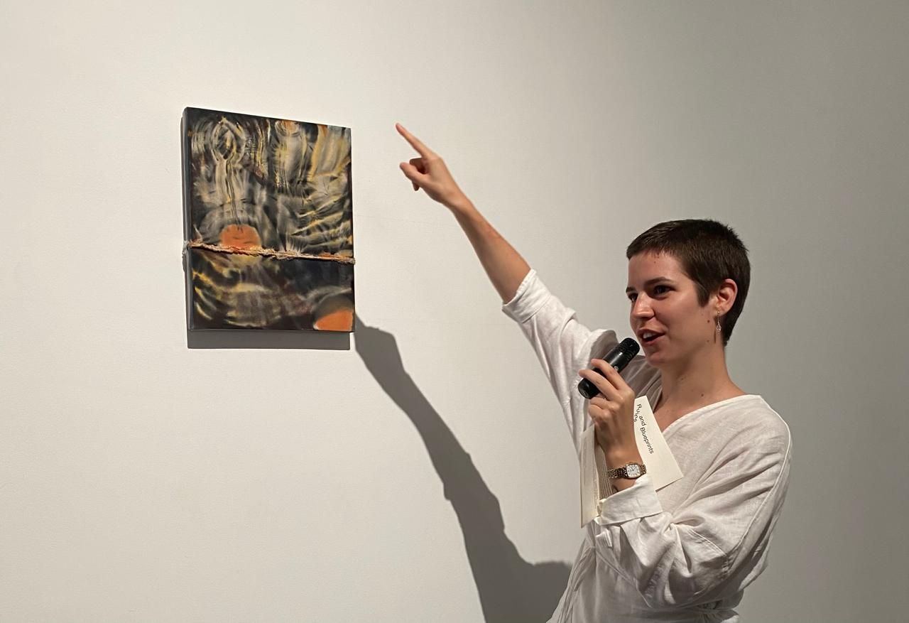 Carmen Ceniga Prado tengah menjelaskan karya lukisnya. Sumber: Lucius GK