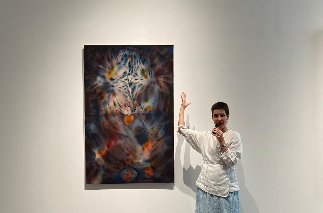 Carmen Ceniga Prado tengah menjelaskan karya lukisnya. Sumber: Lucius GK