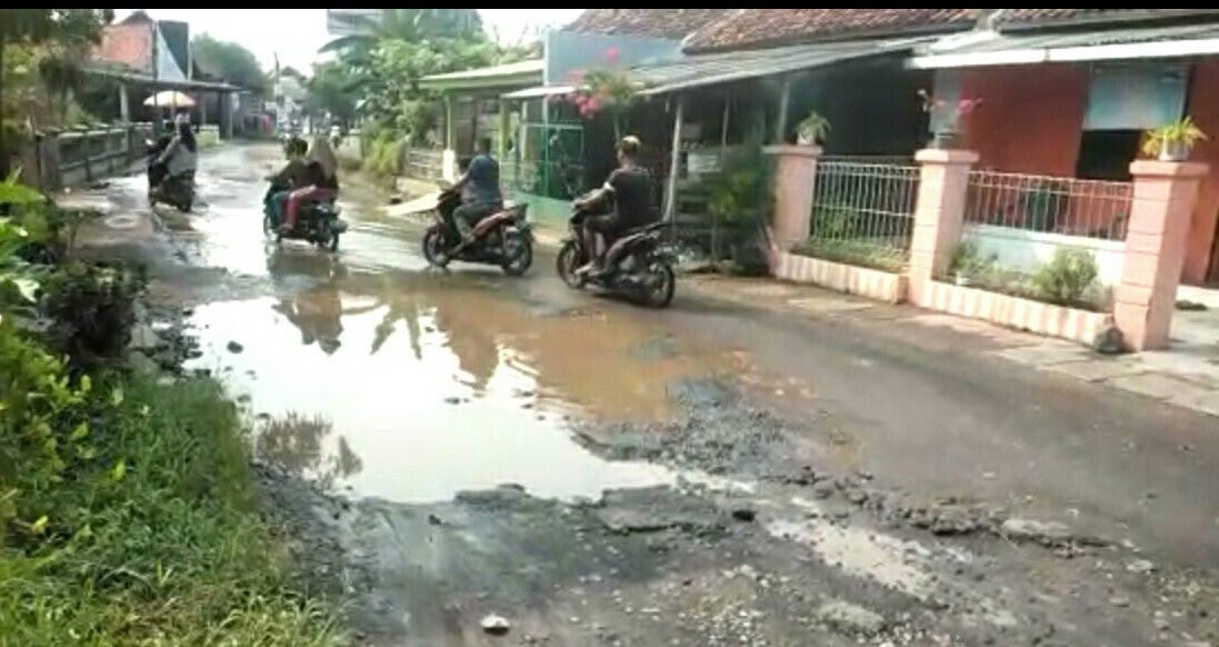 PENGENDARA motor melintasi jalan rusak di Desa Babakangebang Kecamatan Babakan Kabupaten Cirebon, Jumat (1/7/2022).*Supra/KC