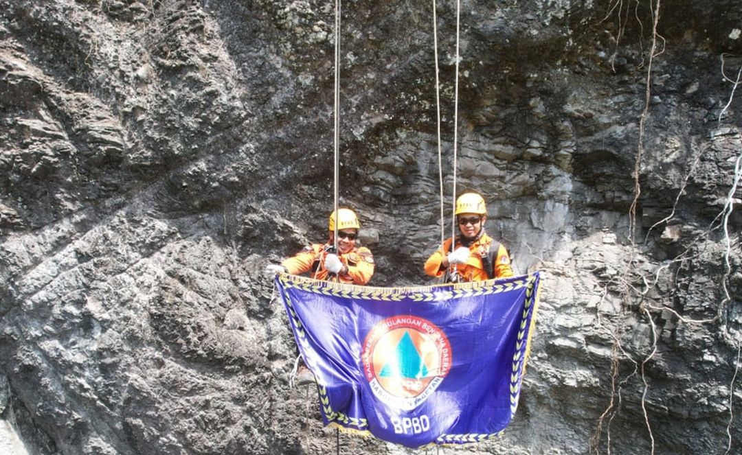 Personel BPBD Magetan usai  mengibarkan bendera merah putih raksasa di tebing ektrem