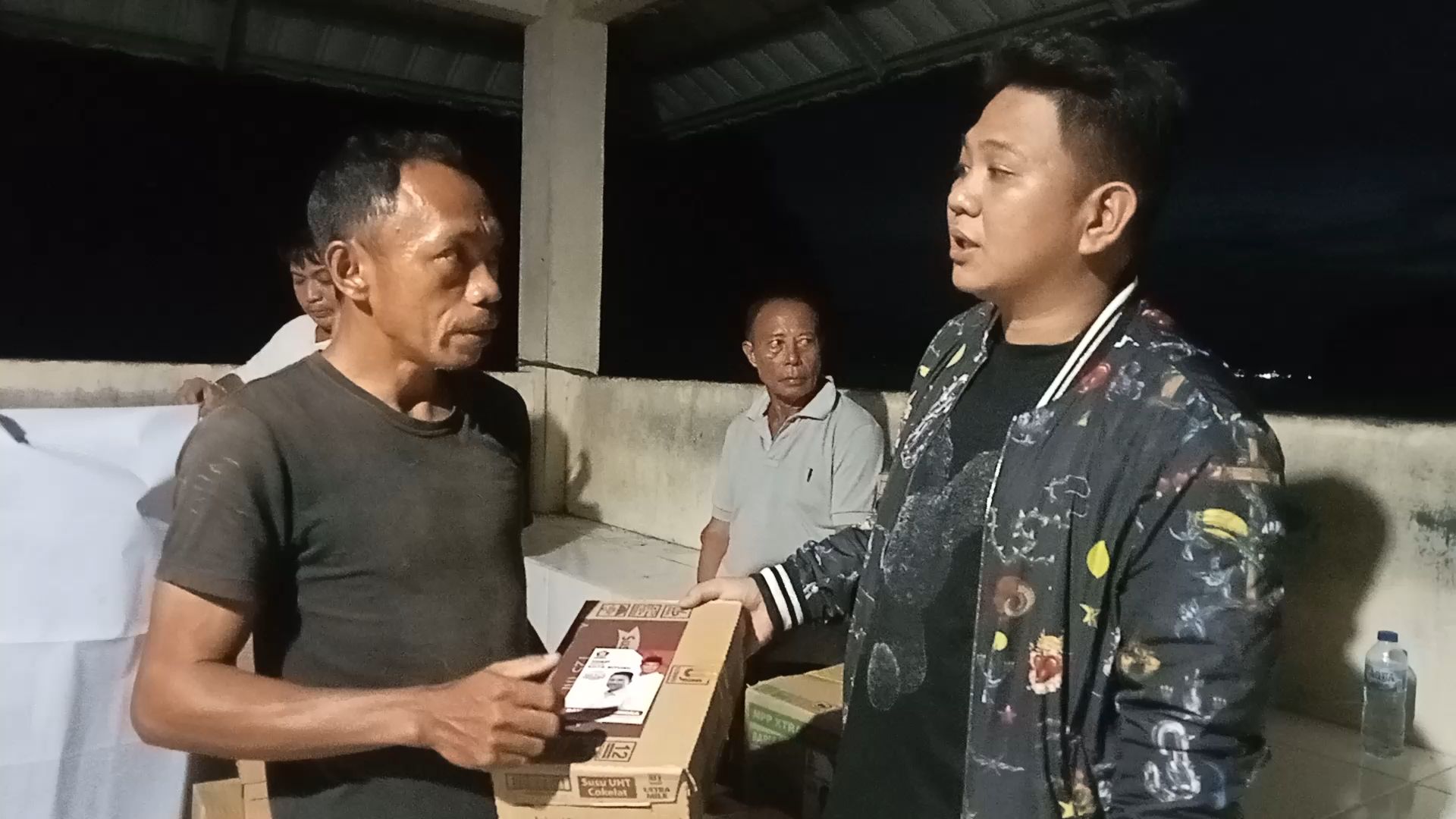 Kepala Lingkungan I Kelurahan Batukota Kecamatan Lembeh Utara menerima bantuan yang diserahkan Ketua DPC Partai Gerindra Kota Bitung Randito Maringka 