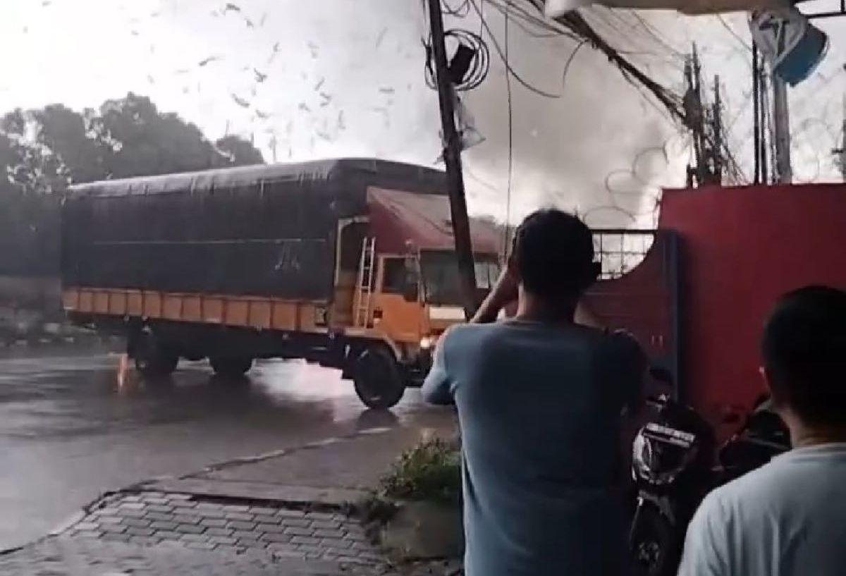 Warga mengambil gambar truk tronton yang melintang di Jalan Raya Bandung-Garut saat angin puting beliung  menerjang kawasan Rancaekek dan Cileunyi Kabupaten Bandung, Rabu 21 Februari 2024.
