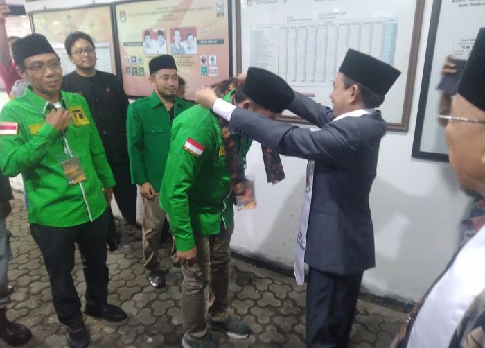 Ketua KPU Kota Tasikmalaya Ade Zaenul mengalungkan kain batik kepada salah satu pimpinan partai yang mendaftarkan bacalegnya di Kantor KPU Kota Tasikmalaya pada Kamis, 11 Mei 2023.