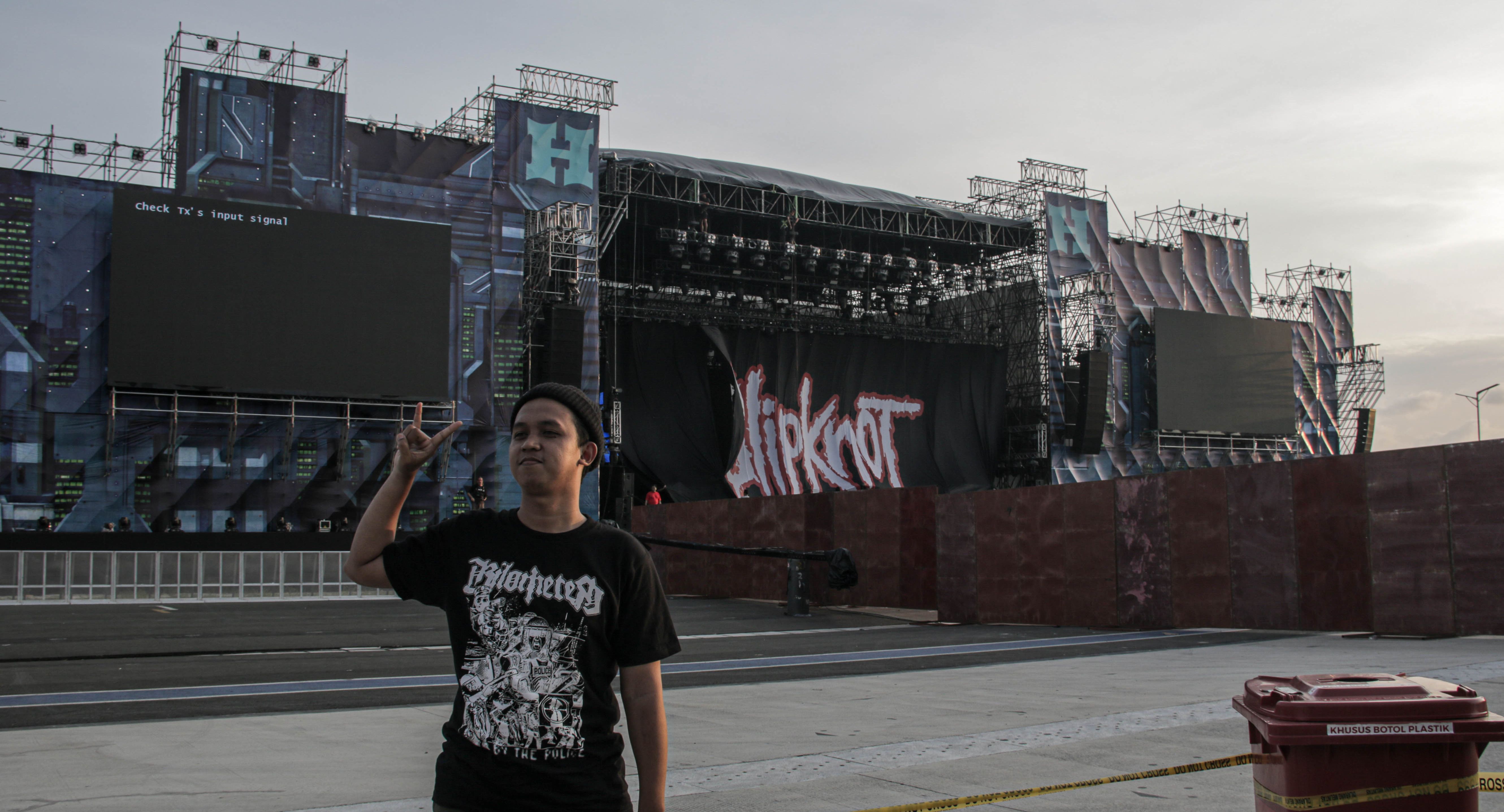 Penonton berfoto di depan panggung Slipknot yang sedang dipersiapkan sehari menjelang konsernya di Hammersonic 2023. Slipknot akan tampil pada 19 Maret 2023 di Pantai Karnaval Ancol.