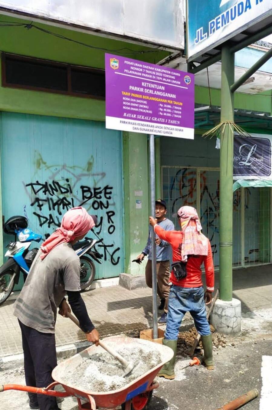 Para pekerja dan petugas dari Dishub Kab.Ciamis tengah memasang papan pengumuman ketentuan tarif parkir berlangganan di Jalan Pemuda, Kelurahan Ciamis, Sabtu 25 Maret 2023.