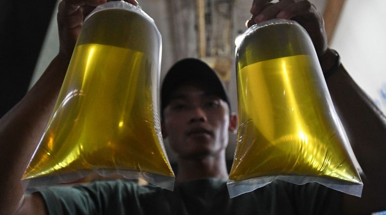 Pedagang menunjukkan plastik berisi minyak goreng curah di Pasar Senen, Jakarta, Selasa, 31 Mei 2022. pembelian minyak goreng curah kini harus menggunakan aplikasi PeduliLindungi.