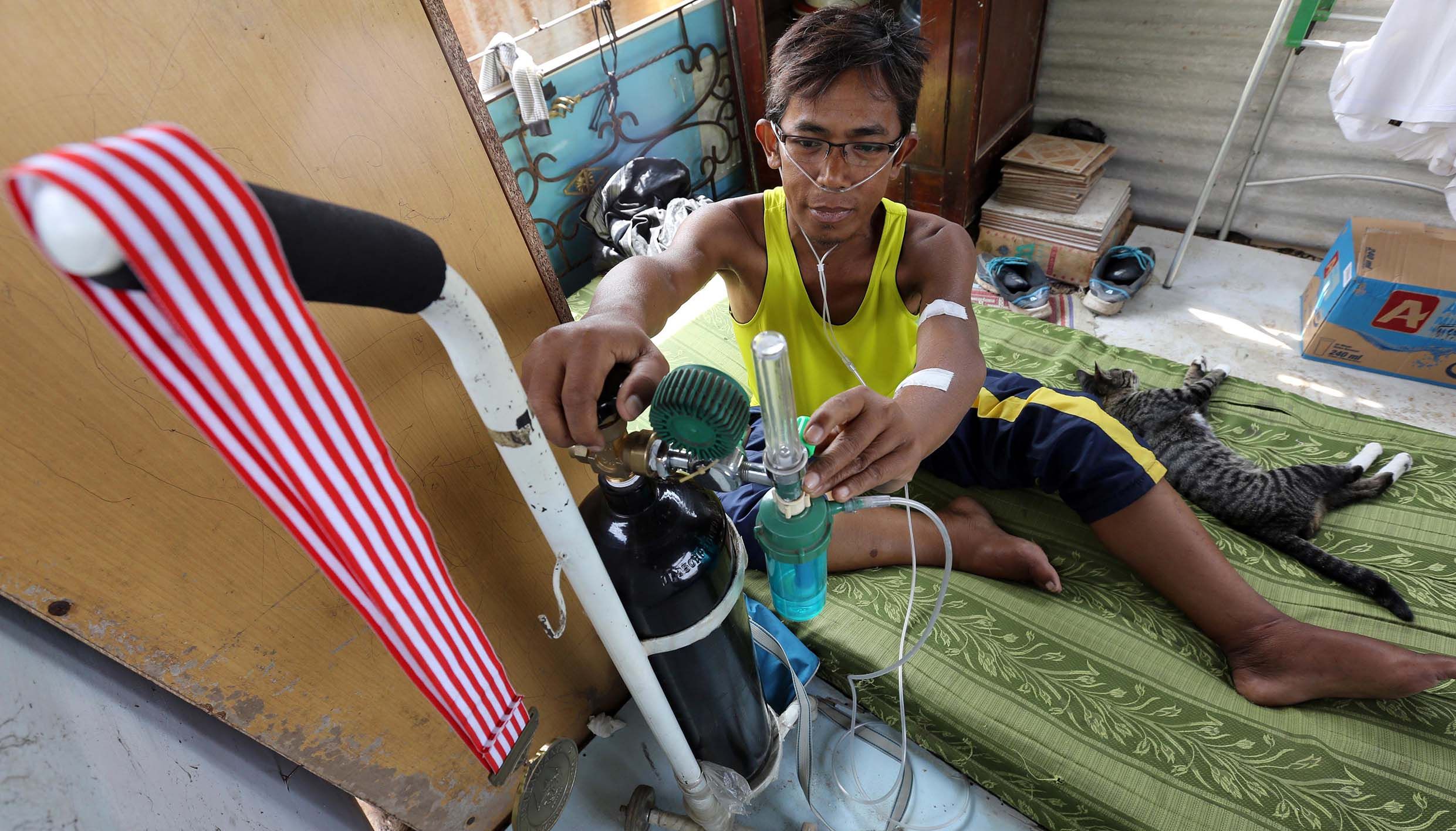 Mantan atlet senam Jawa Barat Amin Ikhsan (42) mengukur tekanan oksigen yang dia hirup di tenda sementara di kawasan bongkaran RT 01 RW 03 Kelurahan Kebonwaru, Kecamatan Batununggal, Kota Bandung, Minggu, 9 Agustus 2015.