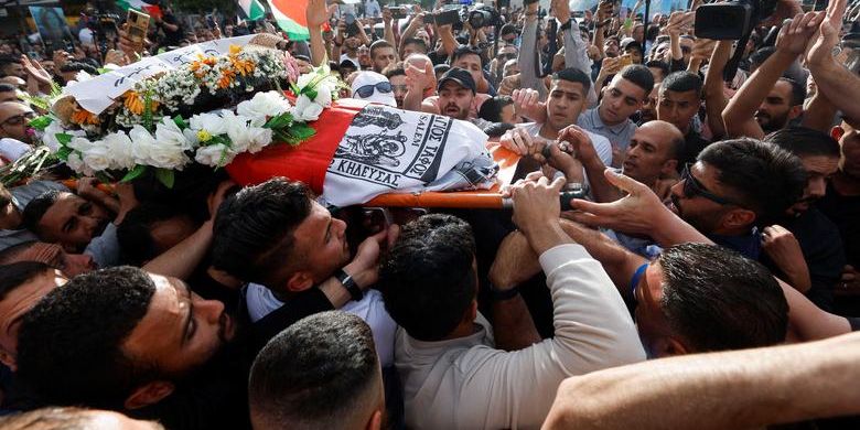 Warga Palestina membawa jenazah reporter Al Jazeera Shireen Abu Akleh, yang tewas dalam serangan Israel, di Ramallah, di Tepi Barat yang diduduki Israel 11 Mei 2022.