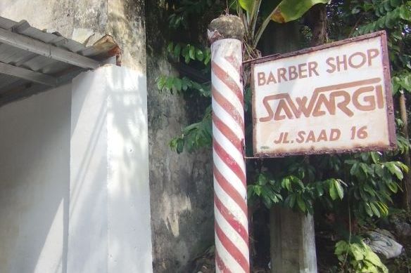 Papan nama Barber Shop Sawargi sejak berdiri tahun 1949 hingga kini tidak berubah, hanya tepat yang berpindah-pindah.