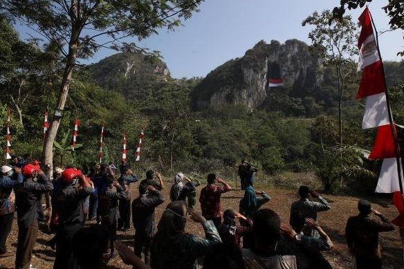 Peserta upacara Hari Kemerdekaan RI ke-76 melakukan penghormatan ke arah bendera merah putih selebar 10X15 meter yang dikibarkan di tebing Gunung Hawu Kampung Cidadap Desa Padalarang Kabupaten Bandung Barat.