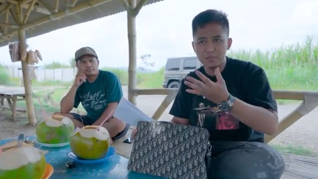Youtuber Doni Salmanan minum kelapa muda pinggir jalan, kemudian ia memberikan uang kepada pedagang kelapa muda itu.