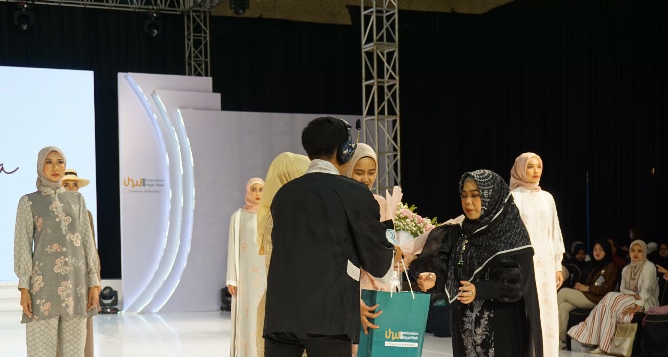 Ketua IHW Dewi Kulsum menyerahkan piagam dan bingkisan kepada salah seorang desainer di akhir acara fashion show Minggu (12/3) malam di Trans Convention Centre, Bandung./foto : ha