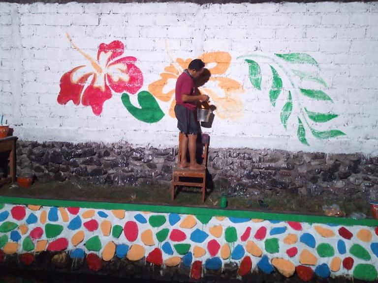 Pemuda Banjar Tegalsari, Desa Tegal Harum Denpasar sedang melukis tembok sekitar Tukad Subak Lange.*/