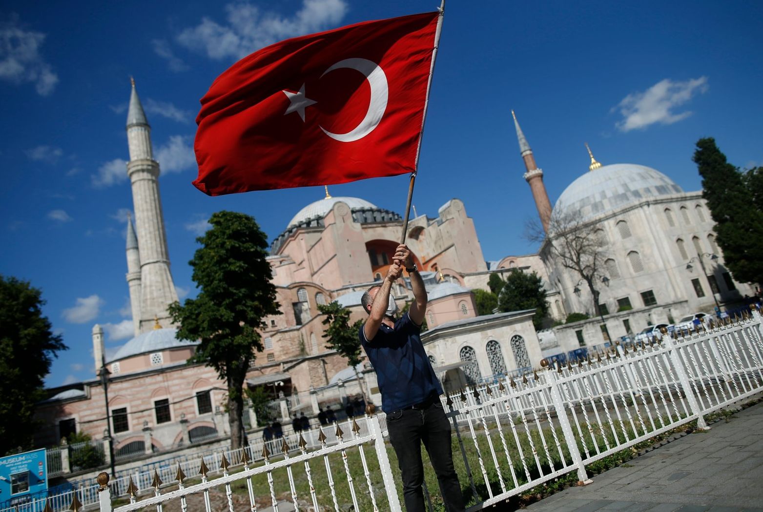 Seorang pria mengibarkan bendera Turki di luar Hagia Sophia era Bizantium, salah satu tempat wisata utama Istanbul di distrik bersejarah Sultanahmet Istanbul,  (AP)
