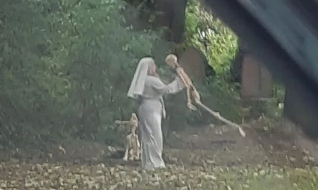 Merinding! Seorang Biarawati Menari dengan Kerangka Manusia dan Anjing di Samping Kuburan