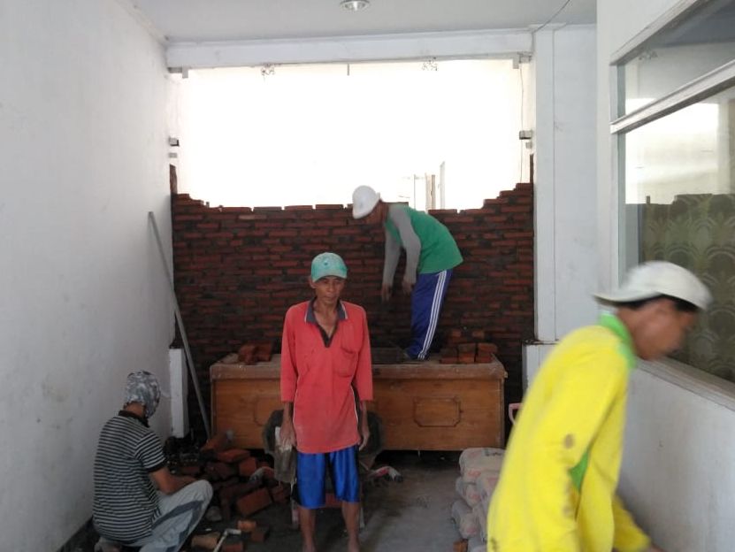Para pekerja sedang mengerjakan tembok sisi depan Gedung Wanita pada Selasa (5/5/2020).*/