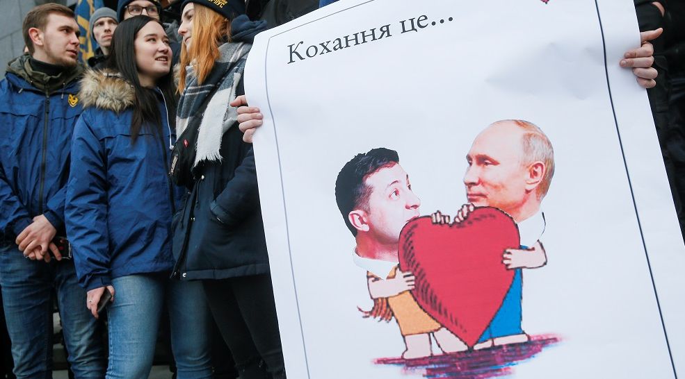 DEMONSTRAN memegang poster bergambar Presiden Ukrainia Volodymyr Zelenskiy dan Presiden Russia Vladimir Putin dalam demonstrasi di Kiev, Ukraina, Jumat 14 Februari 2020.*