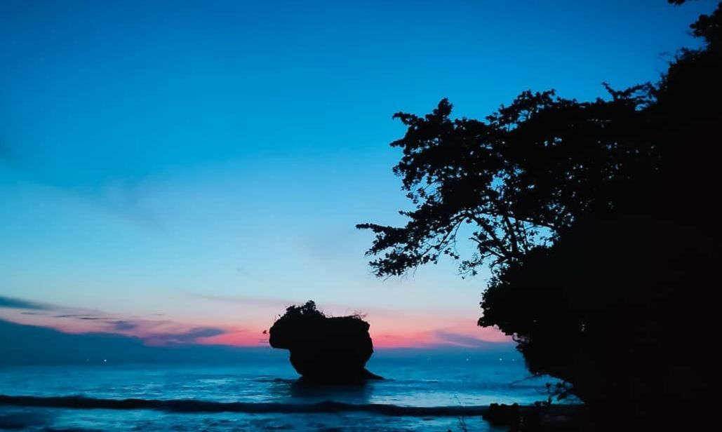 Waktu senja saat matahari baru saja tenggelam di Pantai Madasari, Kabupaten  Pangandaran, Jawa Barat. Nampak pulau kecil yang begitu tenang, asri dan menentramkan jiwa.