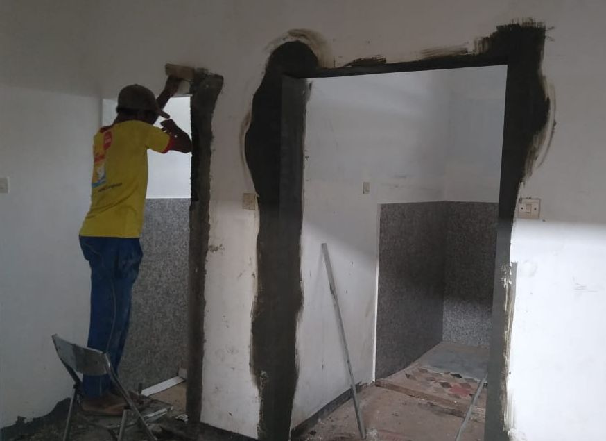 Seorang pekerja sedang menyelesaikan rehab kamar mandi Gedung Wanita Banyuwangi.*/
