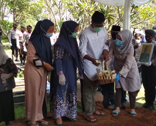 Keluarga Bupati Ade Yasin menaburkan bunga pada prosesi pemakaman  Aiptu Yanwar Permadi di 