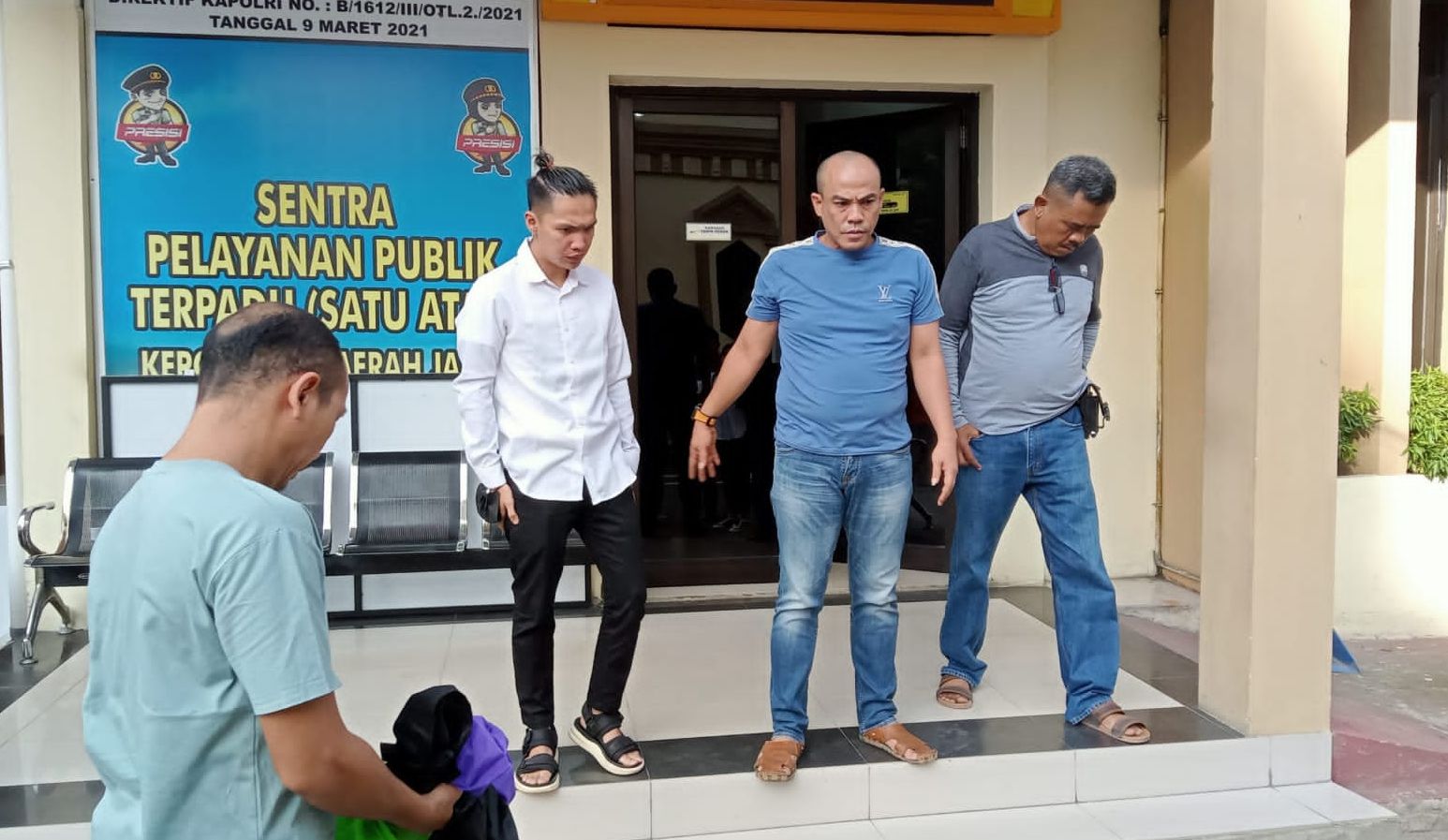 Terlapor (kemeja putih) kasus penganiayaan terhadap seorang wartawan saat menyerahkan diri ke Mapolda Jambi, Minggu sore, 26 Maret 2023.