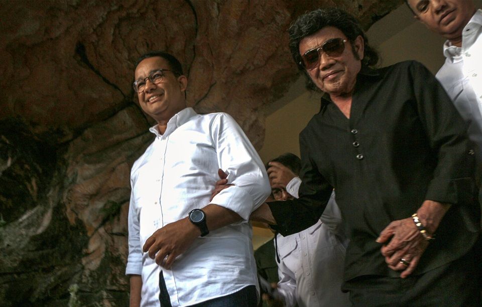 Capres nomor urut 1 Anies Baswedan (kiri) berjalan bersama Rhoma Irama (kanan) saat berkunjung ke markas Soneta Record, Kota Depok, Jawa Barat, Sabtu, 20 Januari 2024.