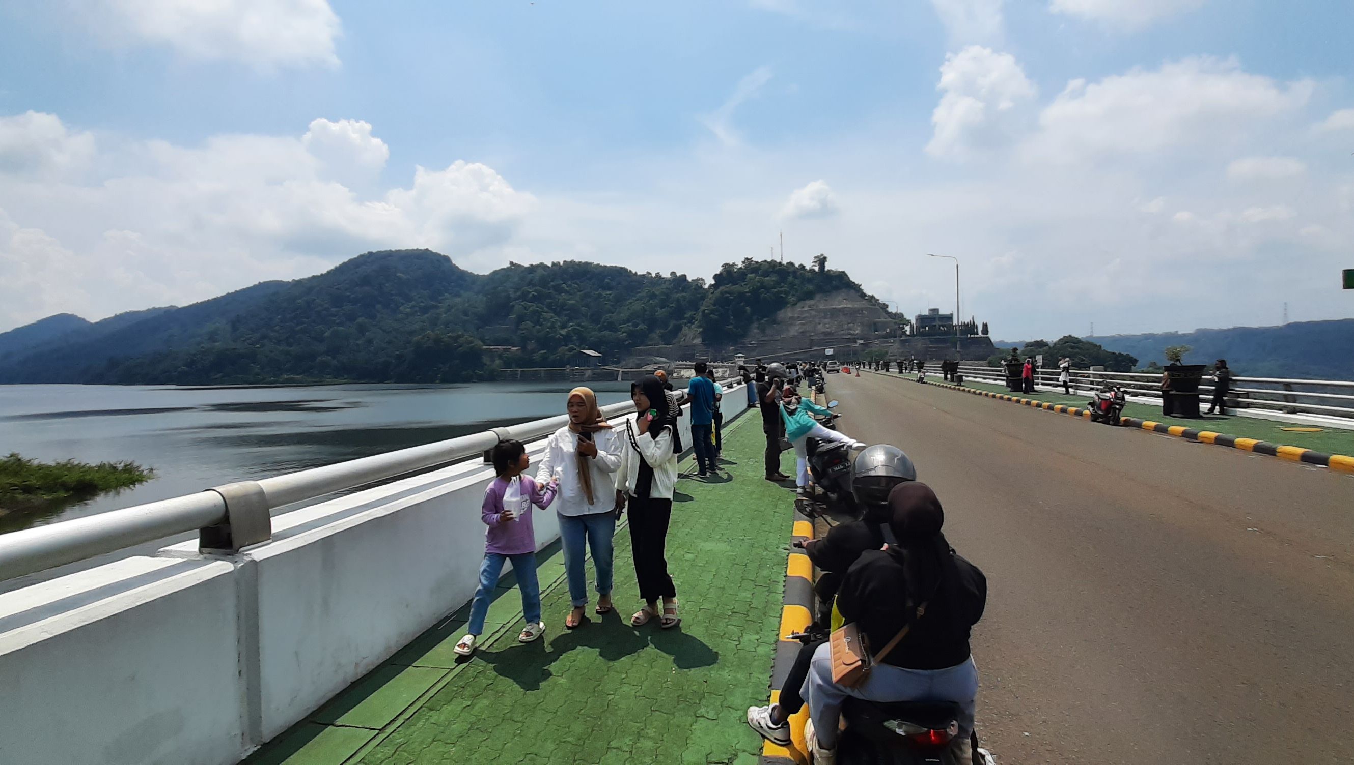 Sejumlah pengunjung menikmati pemandangan bendungan PLTA Cirata di wilayah Kecamatan Cipeundeuy, Kabupaten Bandung Barat, Minggu (14/4/2024). Aksi getok tarif parkir viral di lokasi tersebut belum lama ini.