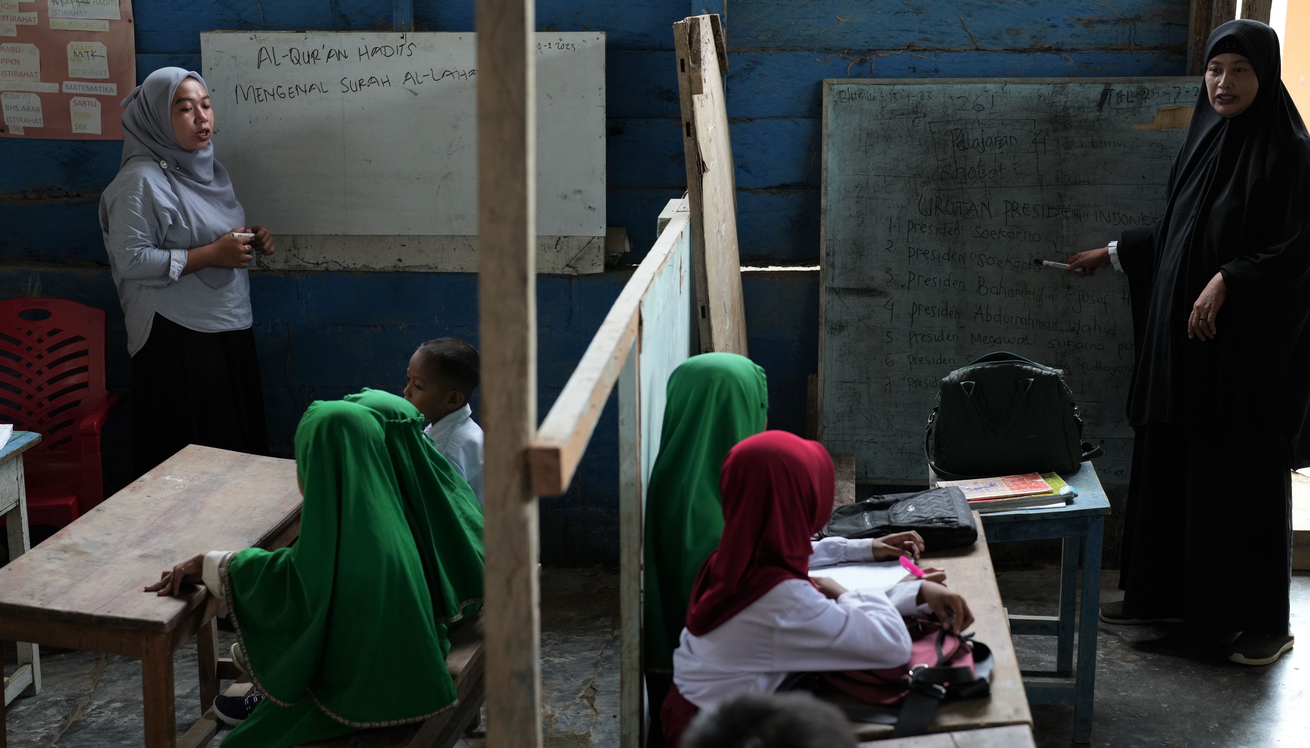 Seorang guru honorer memberikan materi pelajaran di dalam ruang belajar yang sempit di Madrasah Ibtidaiyah Al-Ikhlas di Desa Bajoe, Kecamatan Soropia, Konawe, Sulawesi Tenggara, Selasa 7 Februari 2023.