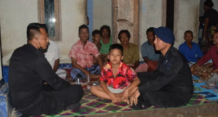 Faris (tengah) saat diserahkan kepada keluarga oleh anggota brimob Polres Lombok Tengah yang melakukan penjagaan di Sirkuit Mandalika. 