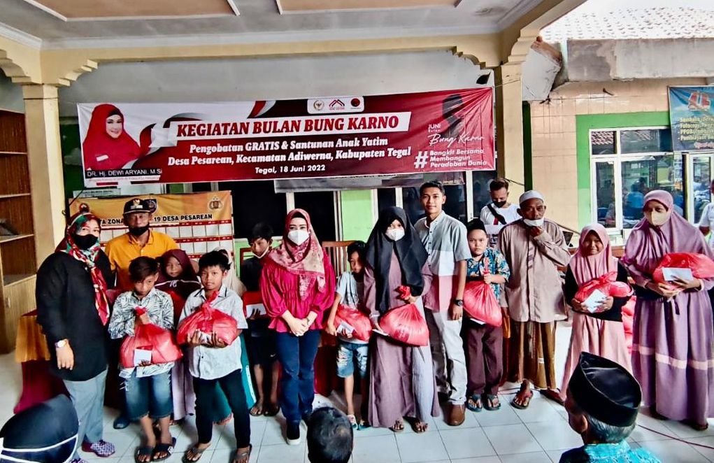 Dewi Aryani berfoto bersama usai memberikan paket sembako dan santunan anak yatim kepada masyarakat Desa Pesarean.
