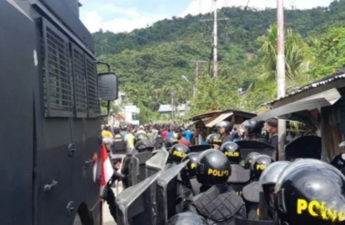 Personel Brimob Polda Papua berupaya menghadang demonstran dengan menggunakan mobil water cannon,  di Jalan Biak, Lingkaran Abepura, Kota Jayapura, Provinsi Papua, Selasa, 10 Mei 2022