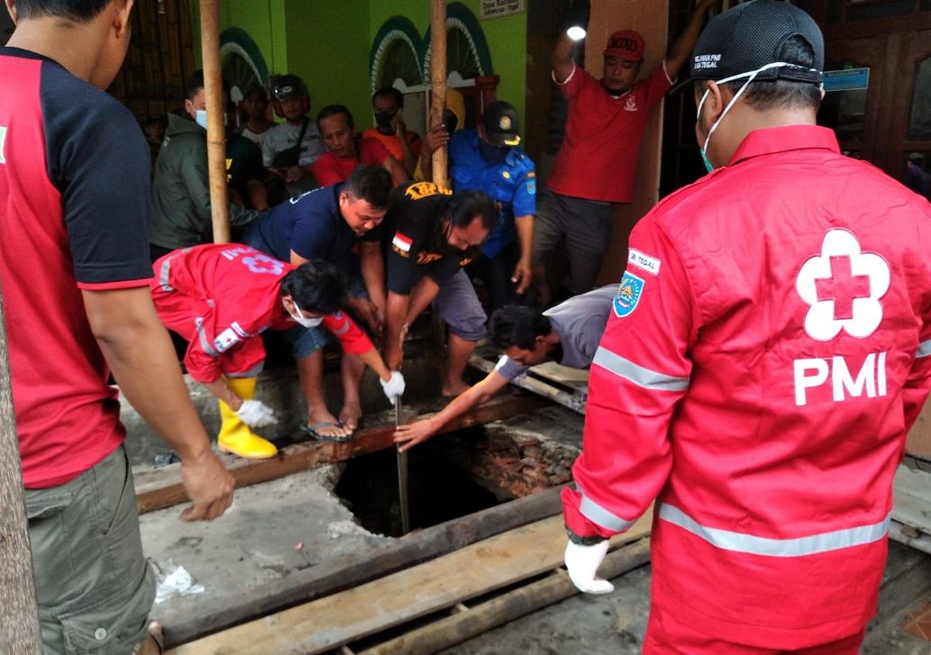 Petugas tengah melakukan evakuasi dua korban kakak beradik yang tewas terperosok ke dalam septic tank