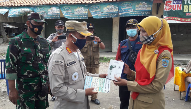 Camat Pangkah Bambang Sihana, menyerahkan satu unit pendeteksi suhu kepada Kepala Pasar, pemberian Tim Koordinator Relawan Gugus Tugas Pusat