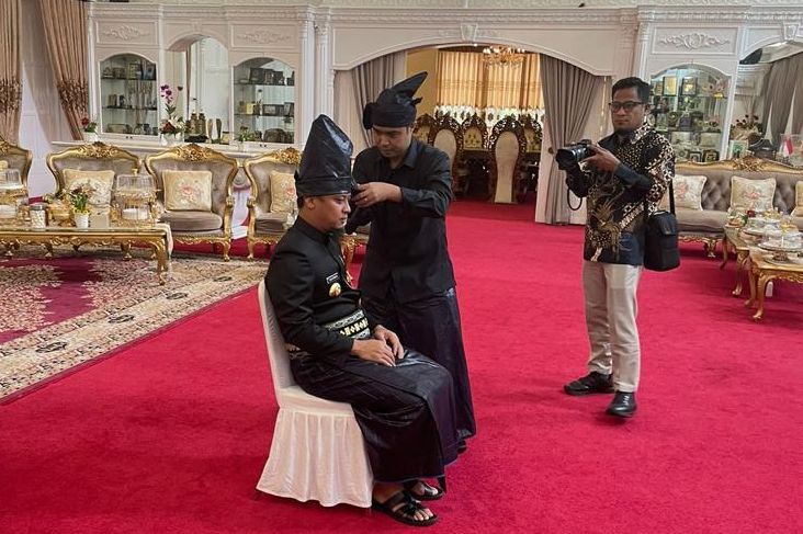 Andi Buyung memeasangkan passapu ke kepala Gubernur Sulsel Andi Sudirman Sulaiman/WartaBulukumba.com