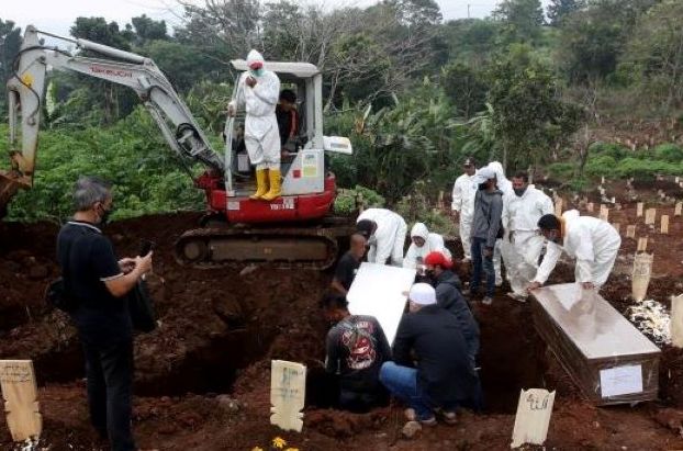 Petugas TPU Cikadut Kota Bandung mengubur jenazah pasien Covid-19 beberapa waktu lalu. Pemkot Bandung berencana akan merekrut warga sekitar menjadi petugas makam untuk menghindari kembali terjadinya praktek pungli.