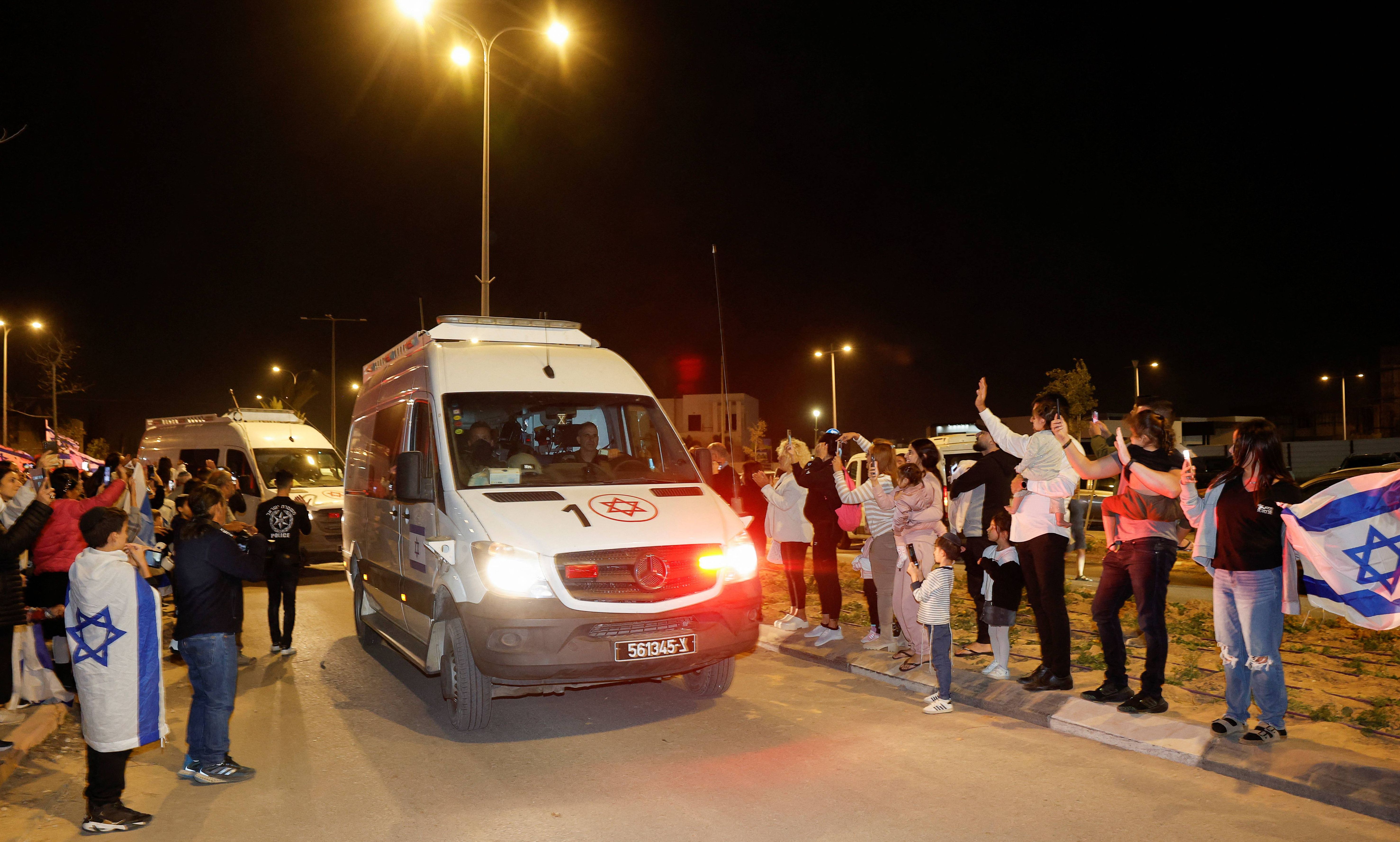 Orang-orang bereaksi terhadap konvoi yang membawa sandera yang baru dibebaskan yang ditangkap dalam serangan 7 Oktober oleh kelompok militan Palestina Hamas dan ditahan di Jalur Gaza, di Ofakim, Israel, 26 November 2023.