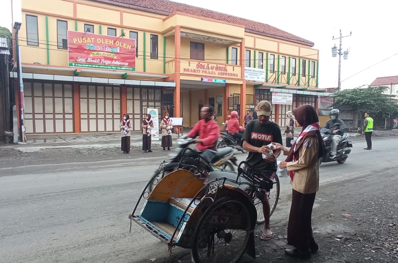 Siswa membagikan nasi bungkus kepada para pengguna jalan didepan sekolah