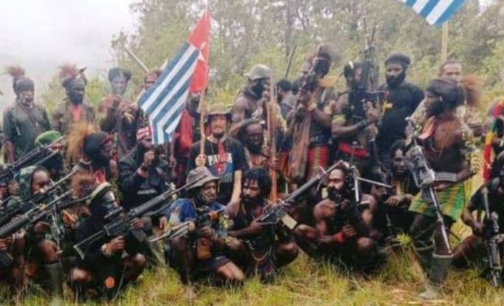Pilot Susi Air Phillip Mehrtens duduk di antara kelompok separatis Papua, dalam gambar selebaran tak bertanggal yang dirilis pada 26 Mei 2023. Tentara Pembebasan Nasional Papua Barat (TPNPB)