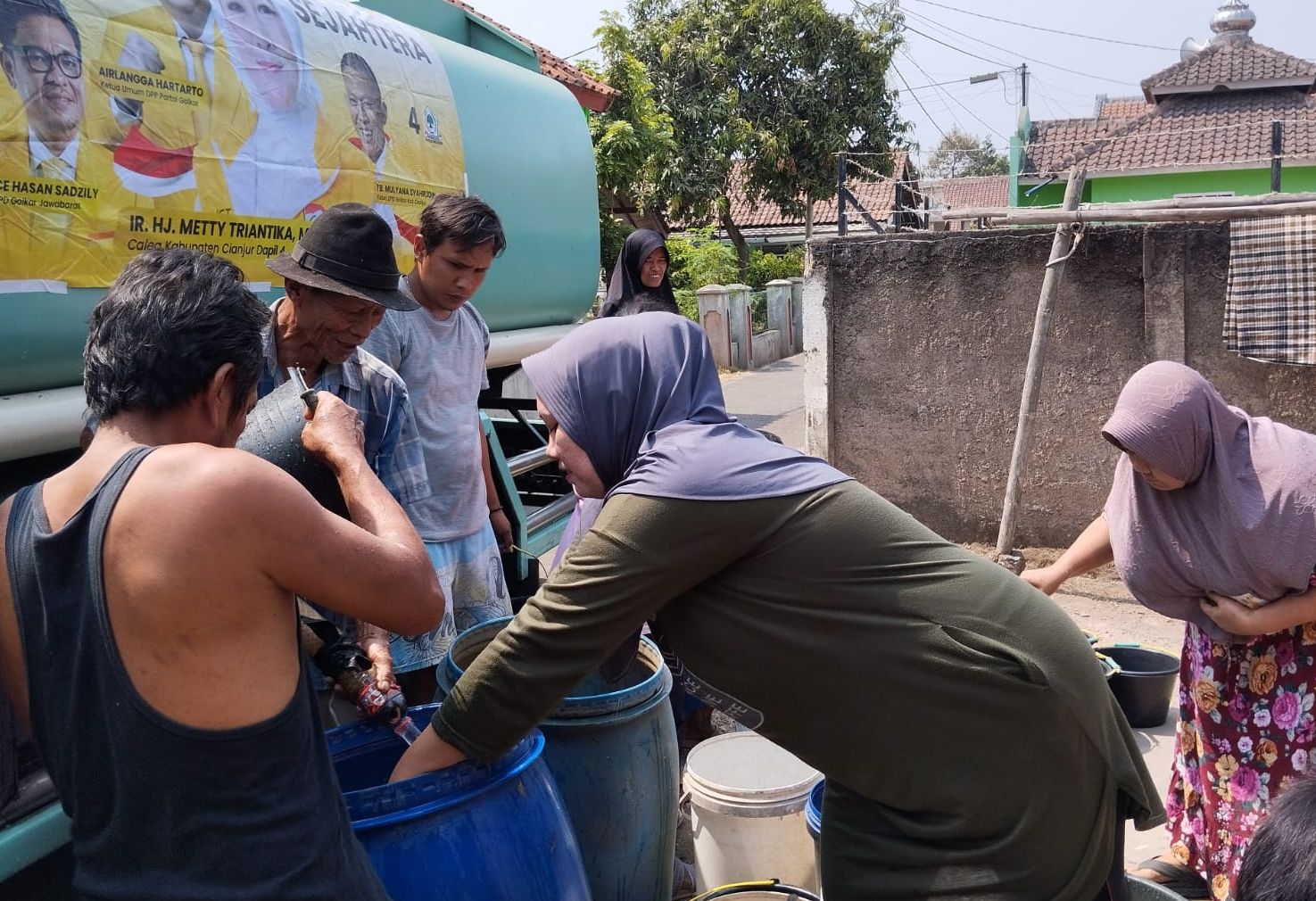 Warga mengambil air bersih yang dikirim Relawan Teh Metty Peduli.