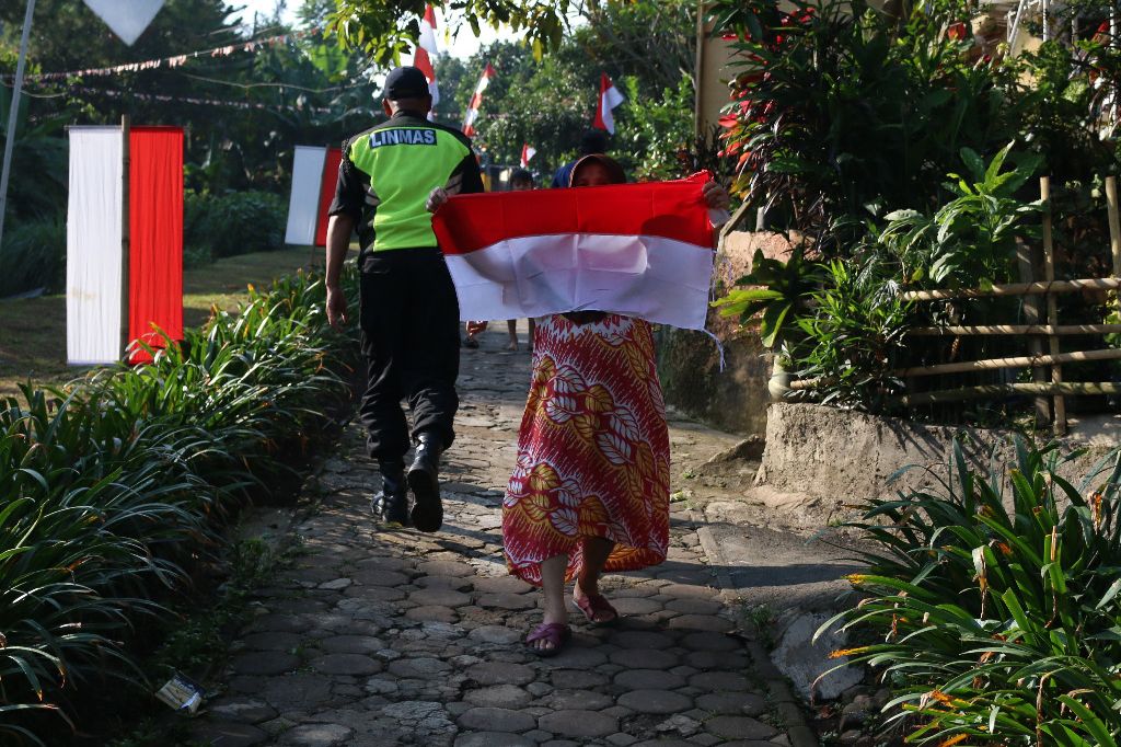 Seorang ibu di Kelurahan Dago kecamatan Cidadap Kota Bandung bersuka cita usai menerima bendera merah putih dari Kadisparbud Jabar Benny Bachtiar.