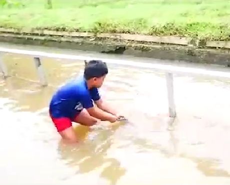Seorang anak menangkap ikan di wisata Minadadi di Desa Wiradadi Sokaraja Banyumas