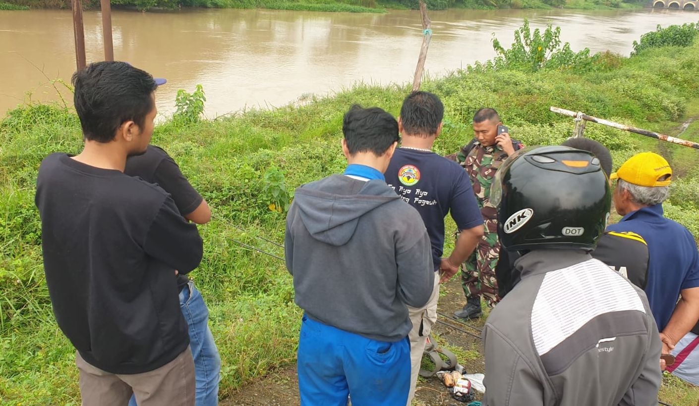 Warga bersama aparat tengah melakukan pencarian salah satu warga Subang yang melompat ke saluran irigasi di Karawang. 
