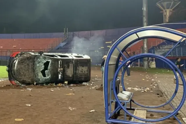 Sebuah mobil polisi rusak di lapangan Stadion Kanjuruhan, Kabupaten Malang, Jawa Timur, Sabtu, 1 Oktober 2022, malam, akibat kericuhan yang terjadi usai pertandingan antara Arema FC melawan Persebaya Surabaya. 