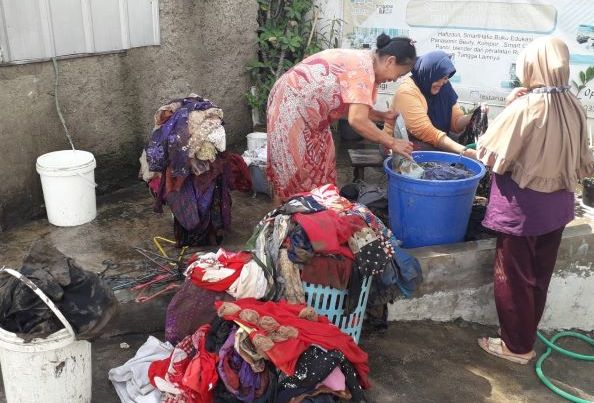 Kaum ibu di Cilember, Kelurahan Cigugur Tengah, Kecamatan Cimahi Tengah Kota Cimahi berbagi air membersihkan pakaian yang kotor terendam air bercampur tanah lumpur luapan sungai Cibeureum.