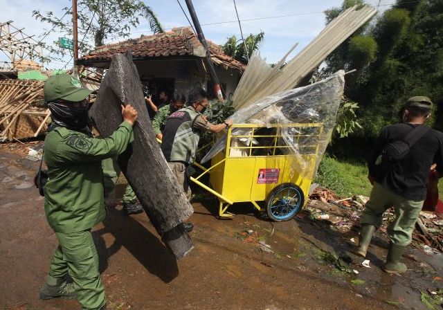 Petugas Linmas Kecamatan Cimenyan turut membersihkan sisa puing-puing yang menutupi akses jalan Ciparalag Desa Mekarsaluyu, Cimenyan Kabupaten Bandung pasca terjangan angin putngbeliung.