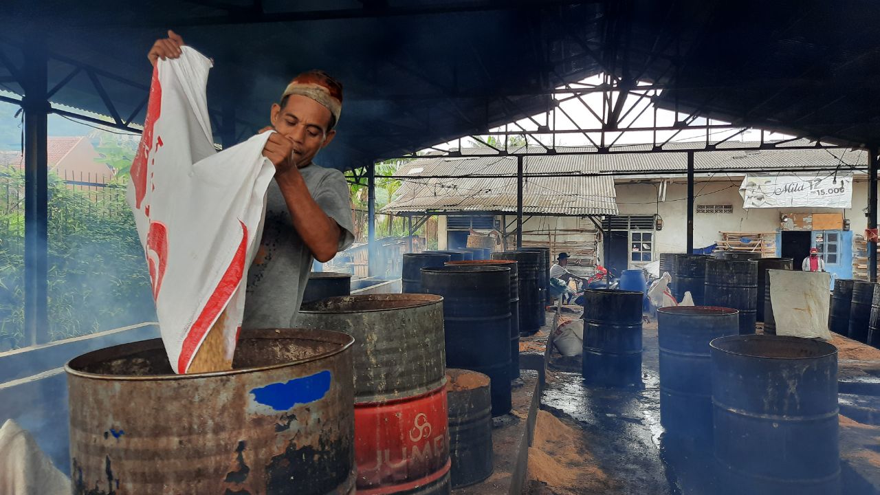 Pekerja mengangkat bahan baku kacang kedelai saat produksi di pabrik tahu dan tempe di Kelurahan Pej