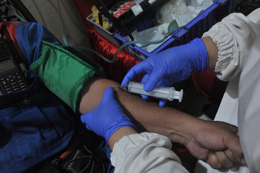 Petugas Palang Merah Indonesia (PMI) mengambil sampel darah dari seorang penyintas COVID-19 yang aka/FENY SELLY/ANTARA FOTO