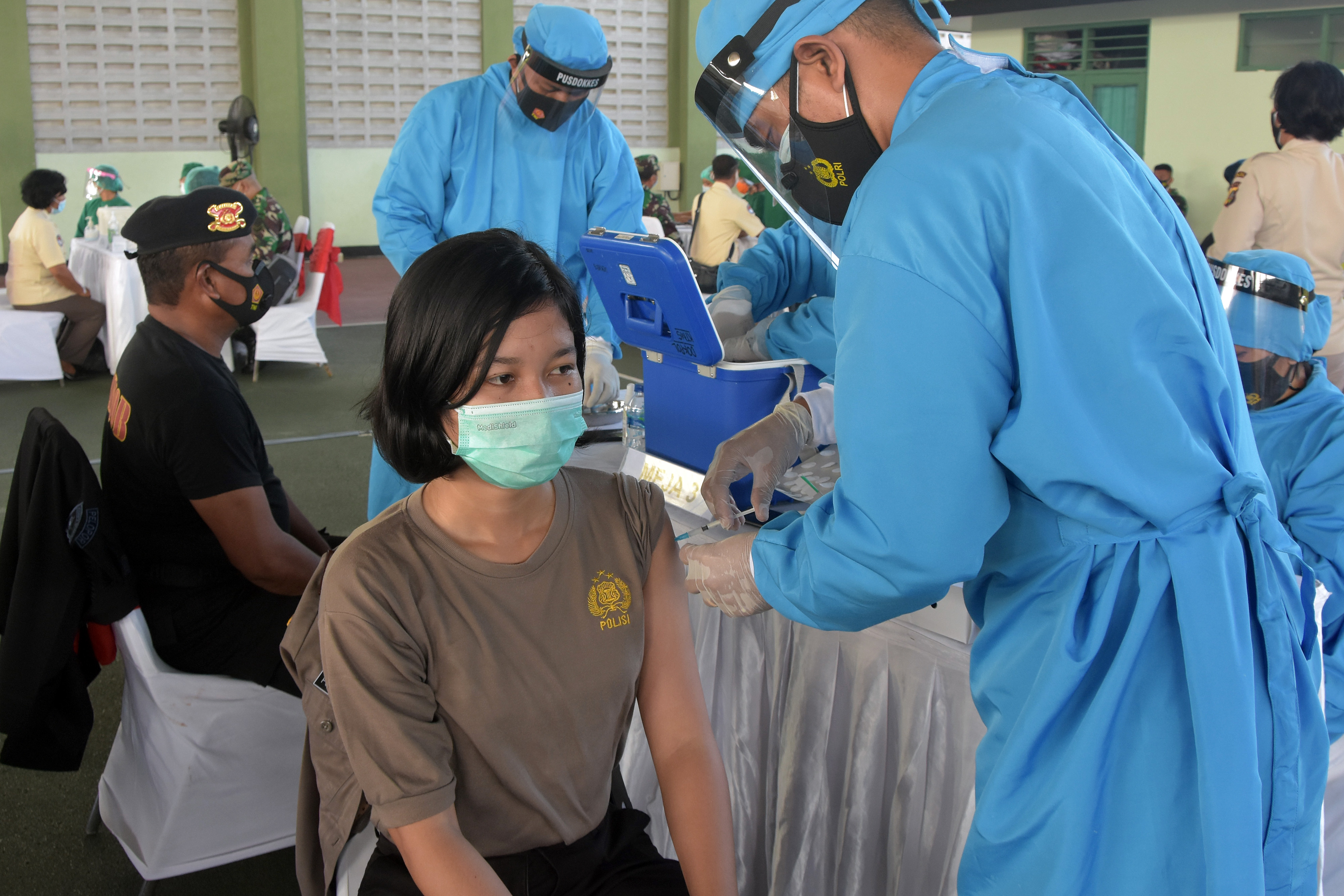 Vaksinator menyuntikkan vaksin COVID-19 kepada anggota Polisi saat vaksinasi anggota TNI-Polri di Ke